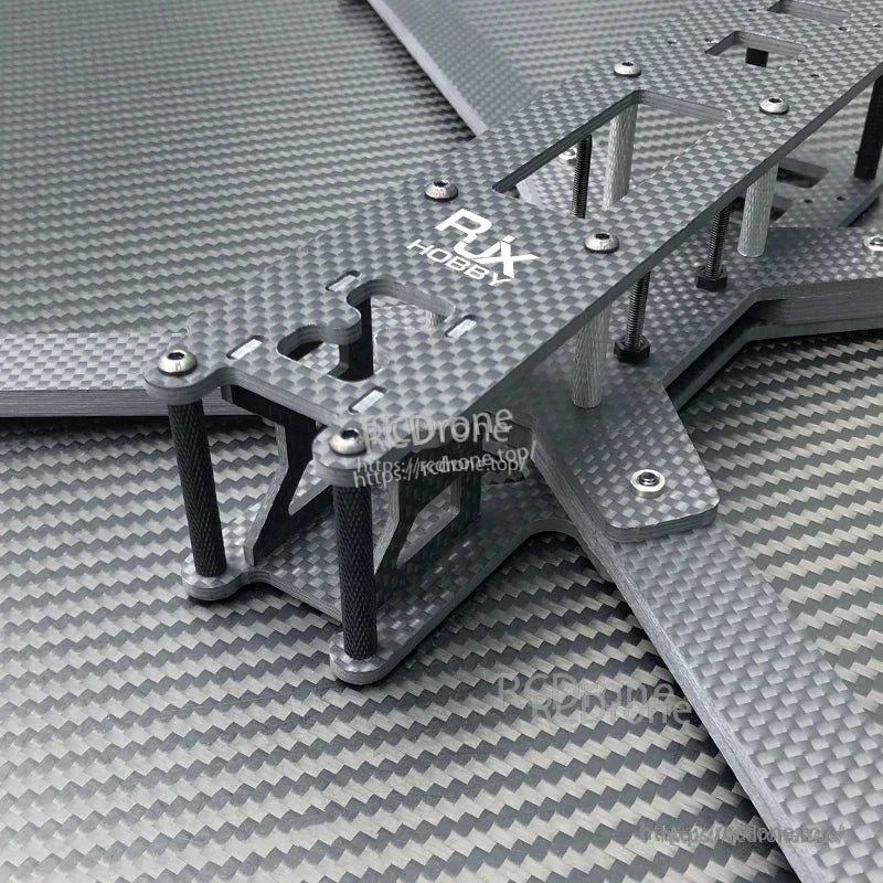 Close-up of RJX carbon fiber 10-inch FPV racing drone frame kit with stacked plates, standoffs, and screws.