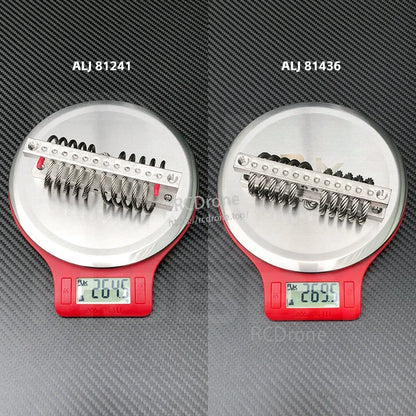 RJX steel wire rope vibration isolator with metal mounting bar on a digital scale, showing about 26.5–27 g weight