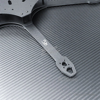 Close-up of RJX carbon fiber FPV drone frame arm with motor mount holes and plate edge