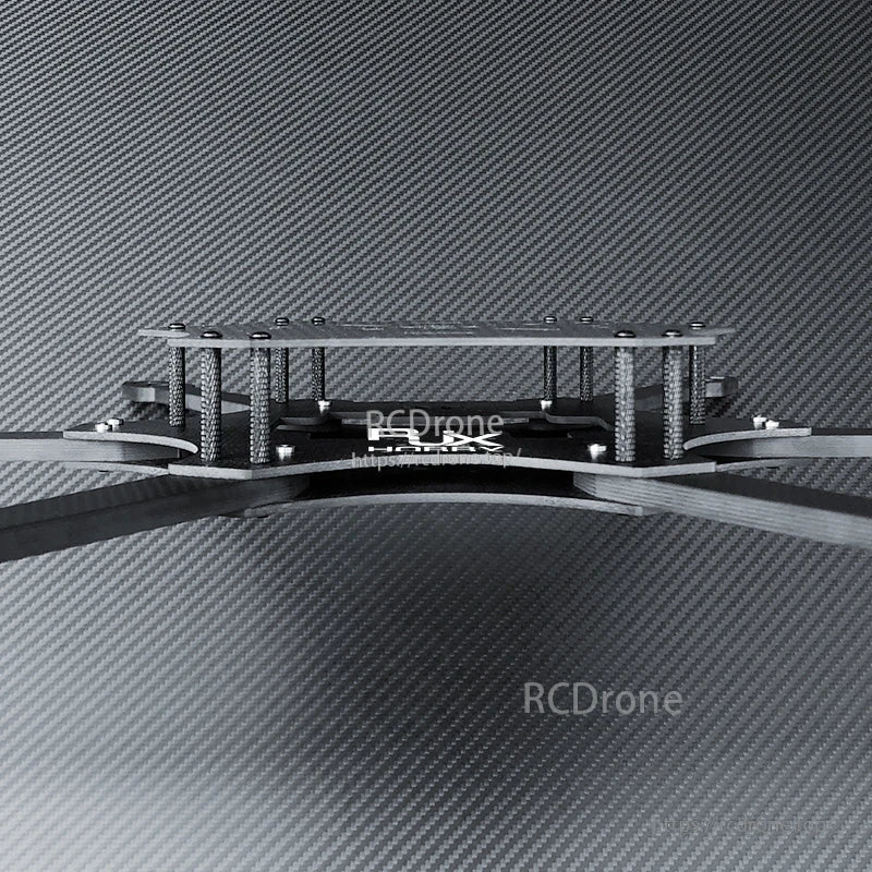 Side view of a carbon fiber FPV drone frame kit showing stacked top plate, standoffs, and extended arms.