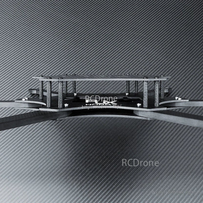 Side view of a carbon fiber FPV drone frame kit showing stacked top plate, standoffs, and extended arms.