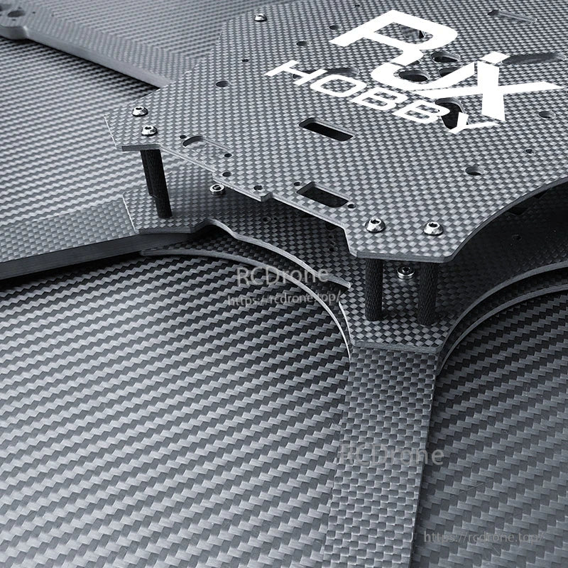 Close-up of RJX carbon fiber FPV drone frame plate with standoffs, screws, and mounting cutouts