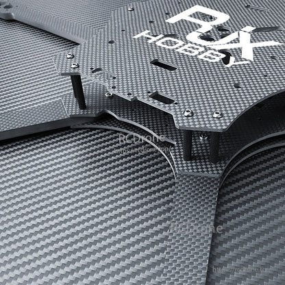 Close-up of RJX carbon fiber FPV drone frame plate with standoffs, screws, and mounting cutouts