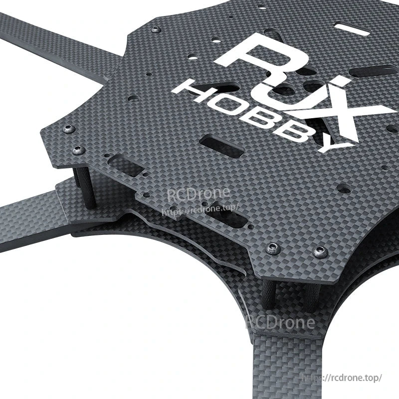 Close-up of RJX carbon fiber FPV racing drone frame top plate with slotted cutouts and standoffs
