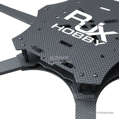 Close-up of RJX carbon fiber FPV racing drone frame top plate with slotted cutouts and standoffs