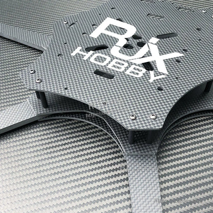 Close-up of RJX Hobby carbon fiber FPV drone frame top plate with cutouts, hardware, and standoffs