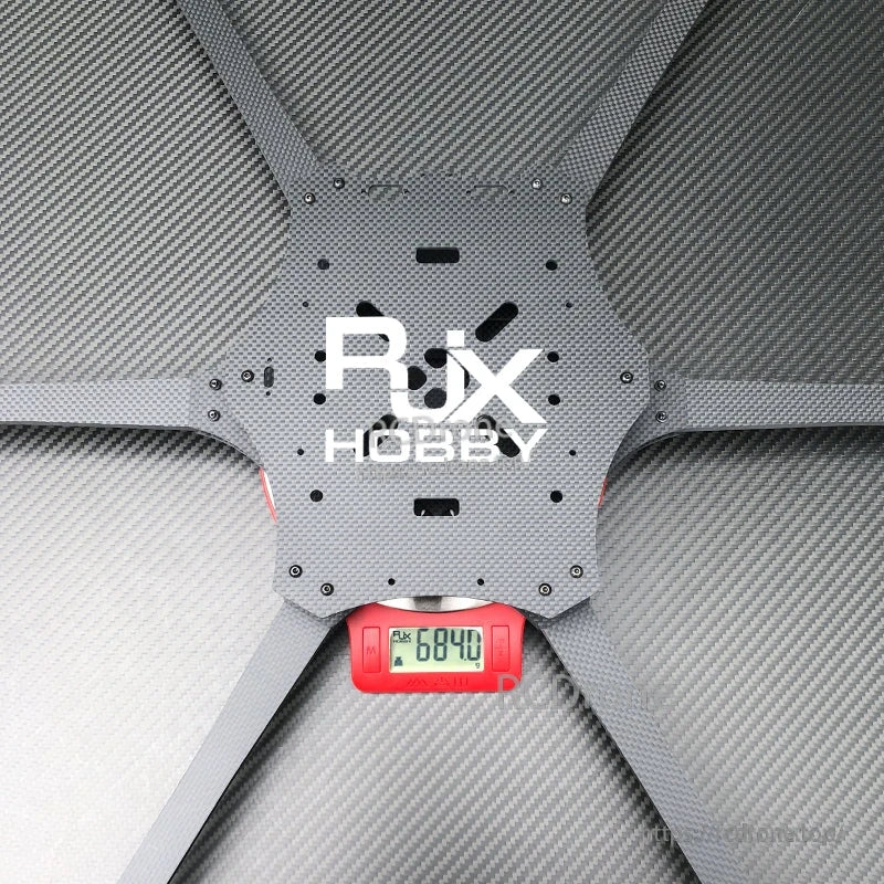RJX Hobby carbon fiber 6-arm FPV drone frame center plate on a digital scale reading 684.0 g