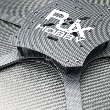 Close-up of RJX carbon fiber FPV drone frame plate with pre-drilled mounting holes, standoffs, and arm
