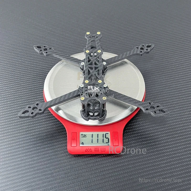 RJX Mark4 V2 carbon fiber FPV quadcopter frame on digital scale with 111.5 g weight reading