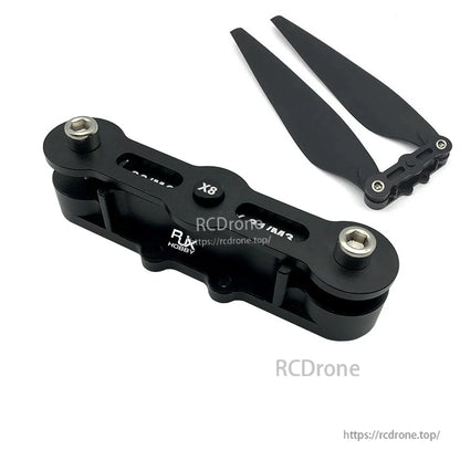 RJX propeller clip with two metal fasteners, shown next to a folded black drone propeller