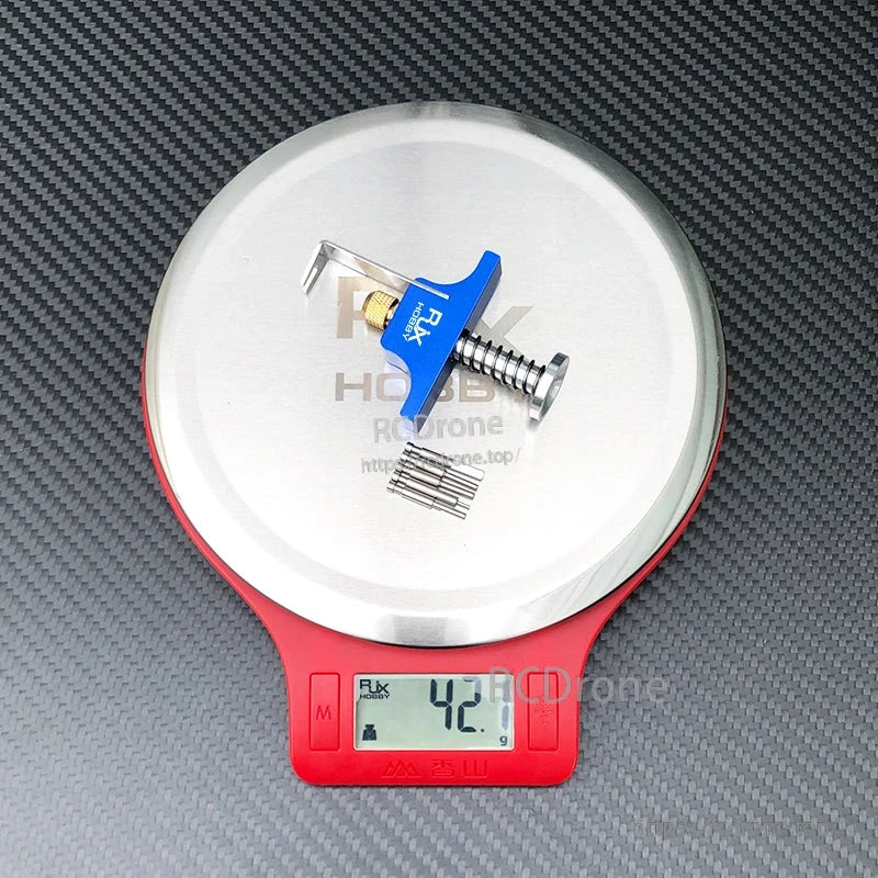 RJX propeller removal tool puller with blue handle and screw mechanism on a digital scale reading 42.1 g