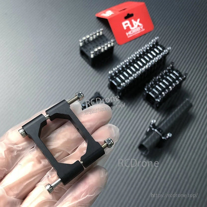 RJX vertical aluminum tube clamp in black, held in hand, with four stainless bolts for tightening around a round tube