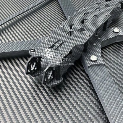 Close-up of RJX carbon fiber FPV drone frame plates and arms with mounting holes, cutouts, and metal standoffs