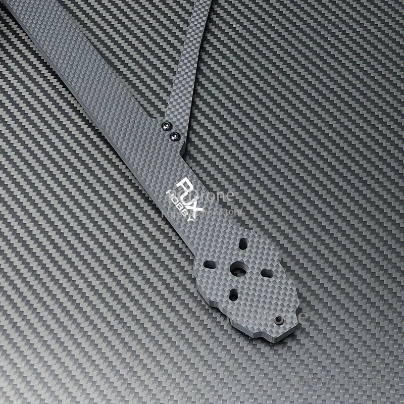 Close-up of RJX X13 carbon fiber FPV drone frame arm with motor mounting hole pattern and logo