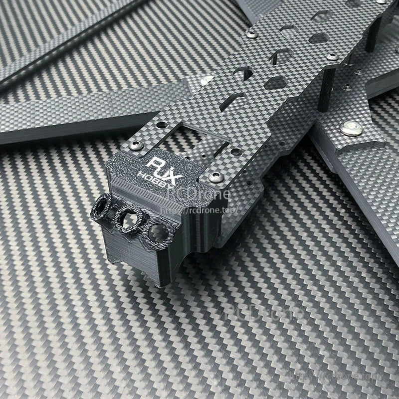 Close-up of RJX X13 carbon fiber FPV drone frame with stacked plates and front TPU mount bracket