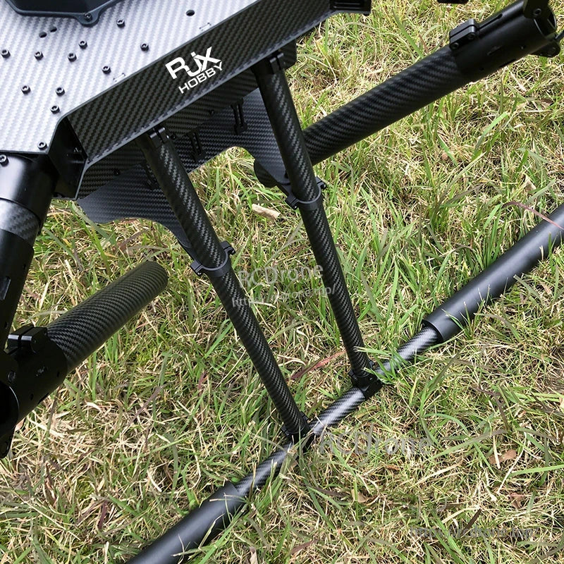 RJX1300C carbon fiber folding quadcopter frame landing gear with triple struts and tubular skids resting on grass