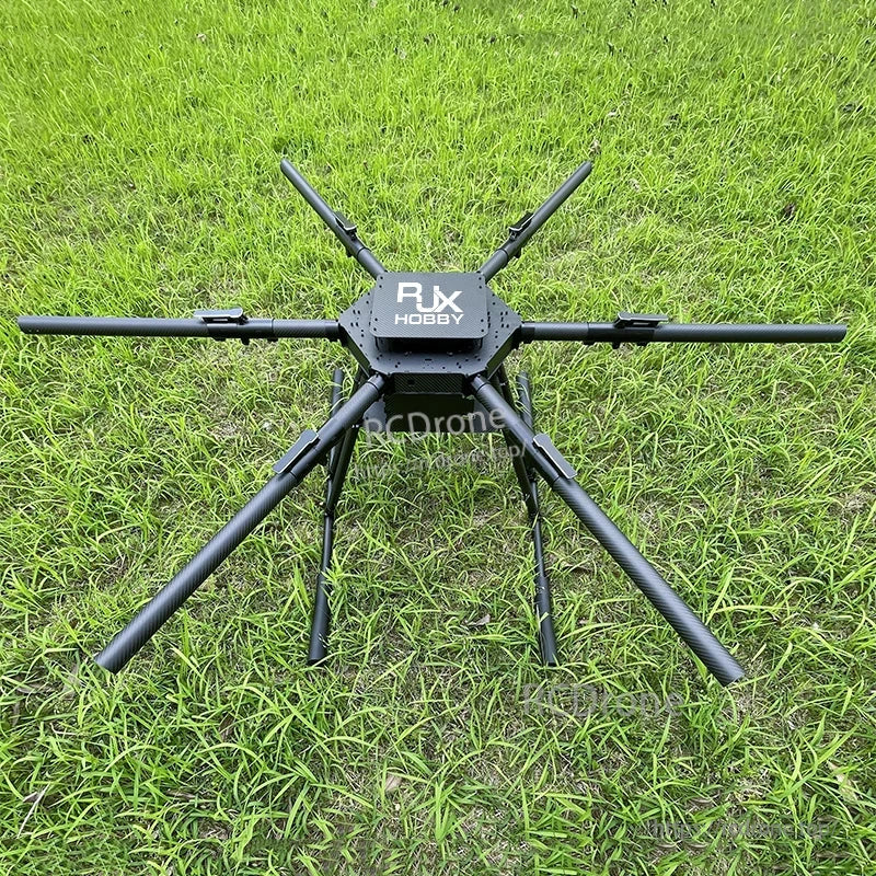 RJX Hobby carbon fiber folding hexacopter frame with six arms, center plate, and landing gear on grass