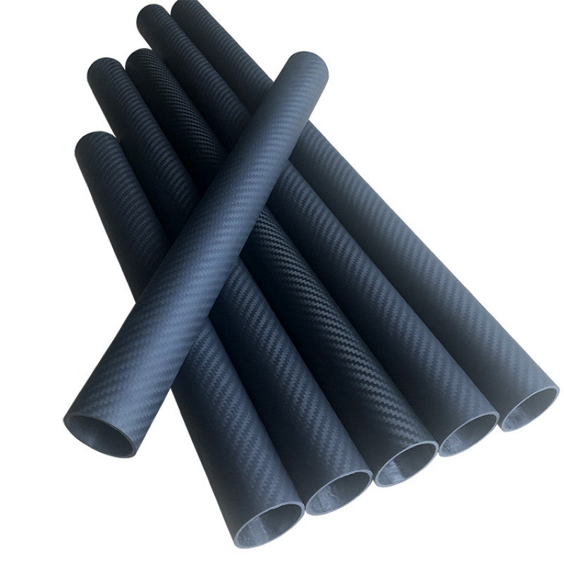 Stack of 3K carbon fiber round tubes with visible twill weave finish and hollow ends