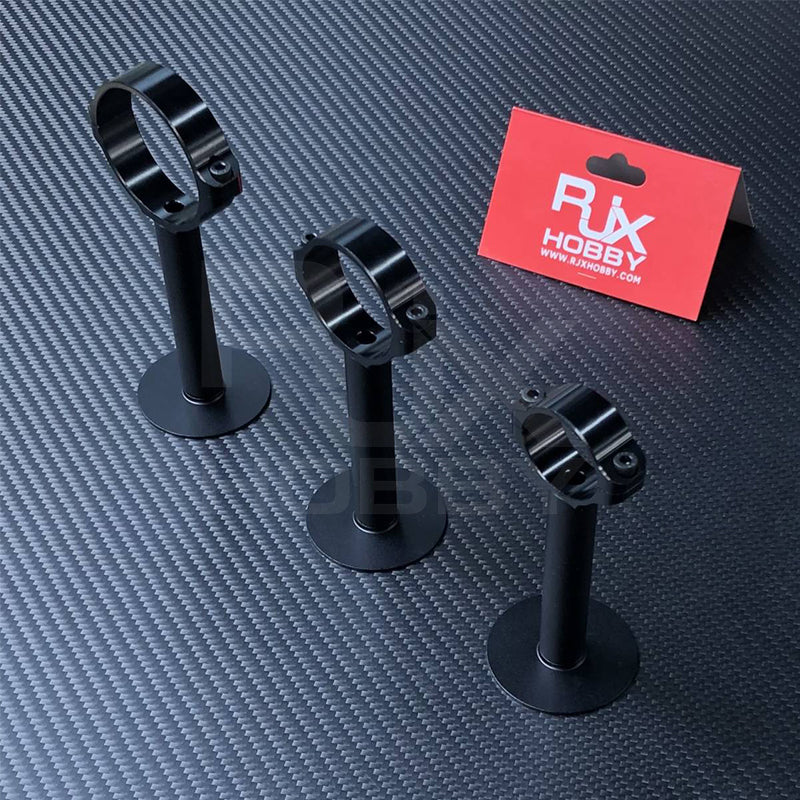 Three black RJX GPS bracket holder mounts with screw clamp rings and round bases on a carbon-fiber surface.