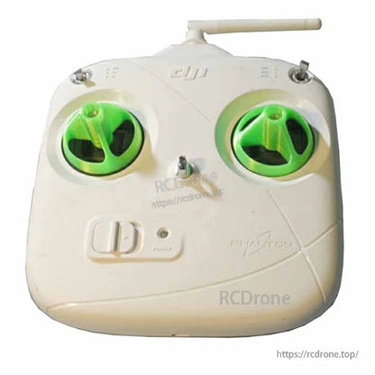 White DJI Phantom RC transmitter with green rocker safety covers installed over both control stick gimbals