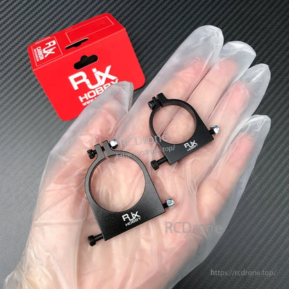 RJXHOBBY 1pc 25mm/30mm Pipe Clamp, Two black RJXHOBBY metal pipe clamps with bolt hardware, shown in hand with red RJX HOBBY packaging
