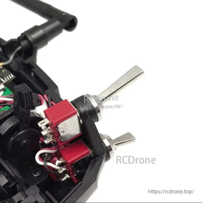 Two flat-handle 2-position toggle switches installed inside an RC transmitter housing, with wired terminals