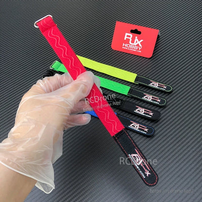 RJXHOBBY non-slip silicone battery strap with metal buckle, shown in red with grip pattern and stitched end tab