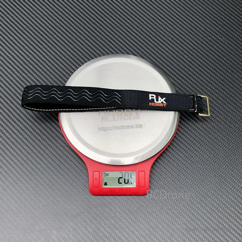 RJX Hobby 25mm non-slip silicone battery strap with Kevlar stitching and metal buckle on a scale (20.5 g)