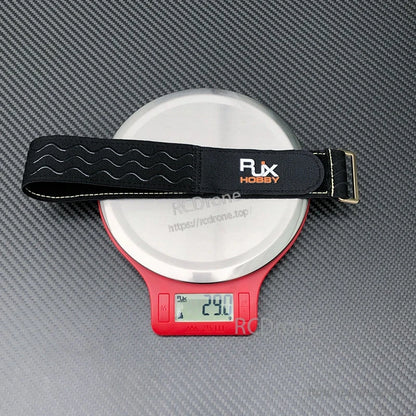 RJXHOBBY black non-slip silicone battery strap with stitched edges and metal buckle, weighing 29g on scale