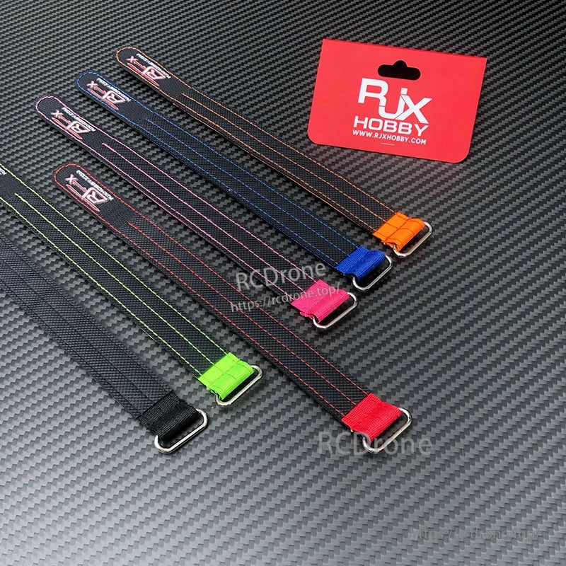 RJXHOBBY 2pcs Kevlar Battery Strap, RJXHOBBY Kevlar battery straps with metal buckle and colored end tabs on carbon-fiber background