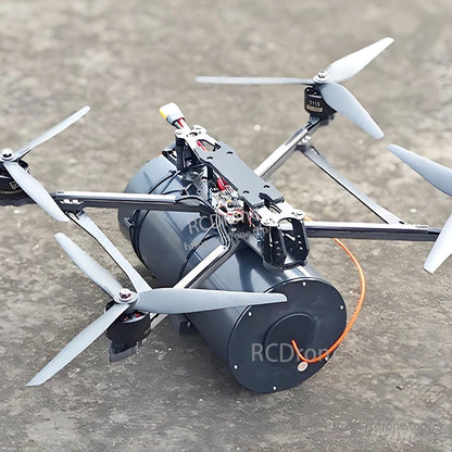 FPV quadcopter mounted on a large black fiber-optic spool with orange tether cable routed to the frame