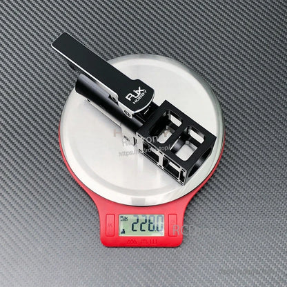 RJXHOBBY black aluminum folding side arm with hinge mount for UAV, resting on a scale reading 228g