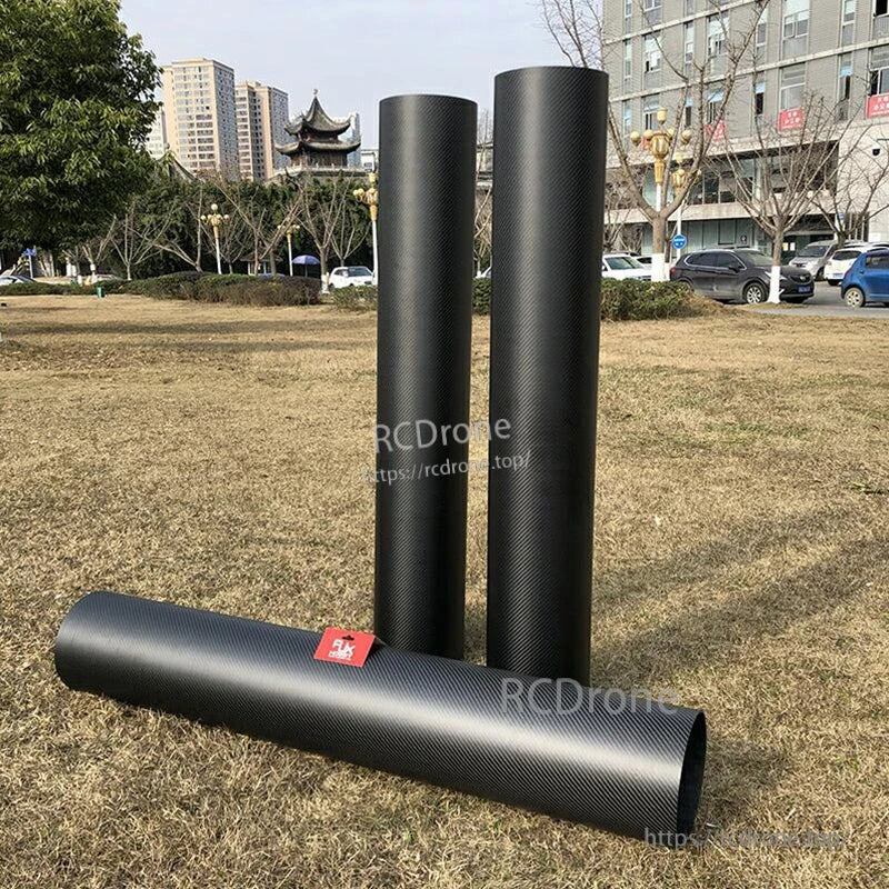 Three RJXHOBBY 3K carbon fiber round tubes with a black woven finish, two standing upright and one lying down
