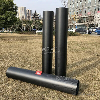 Three RJXHOBBY 3K carbon fiber round tubes with a black woven finish, two standing upright and one lying down
