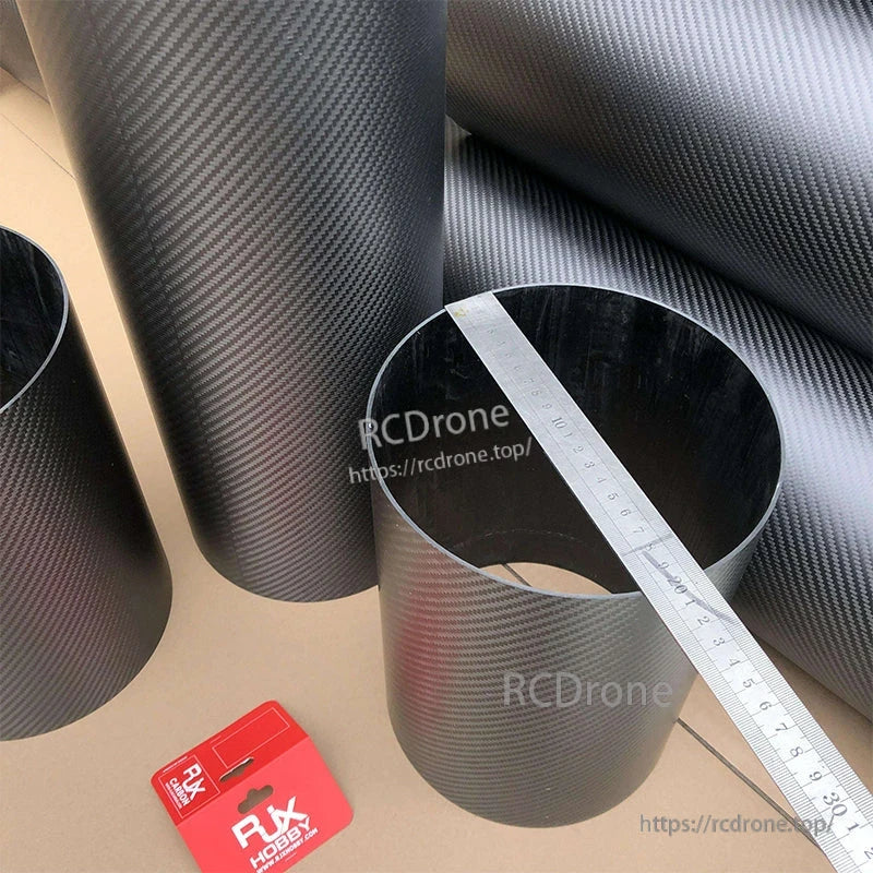 RJXHOBBY 3K Carbon Fiber Round Tube, 3K carbon fiber round tube with twill weave finish, shown with a ruler across the opening for size reference