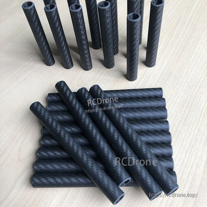 RJXHOBBY 3K Carbon Fiber Round Tube, Stack of round 3K carbon fiber tubes with matte woven finish, shown in multiple cut lengths on a tabletop