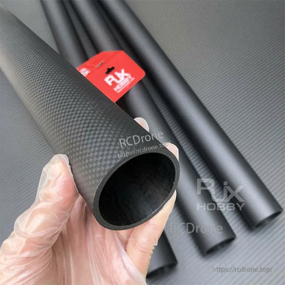 Hand holding RJXHOBBY 3K carbon fiber round tube with glossy weave finish and hollow interior opening
