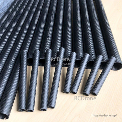 3K carbon fiber round tubes with twill weave finish in assorted diameters, cut ends visible on tabletop