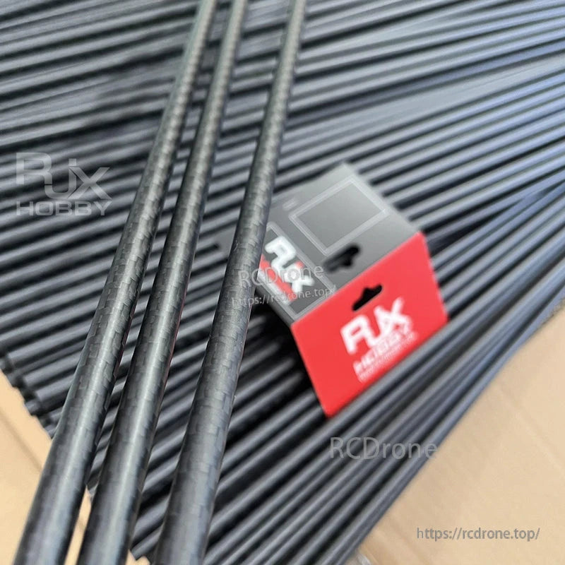 Bundle of RJXHOBBY 3K carbon fiber round tubes with woven finish, long black rods in front of branded box