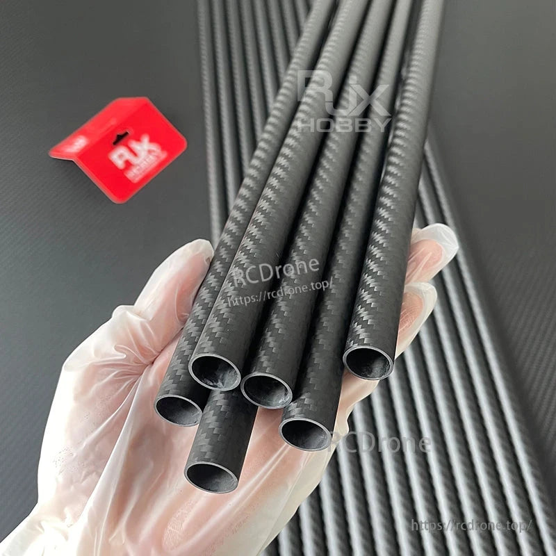 Hand holding multiple 3K carbon fiber round tubes with twill weave finish, lightweight hollow shafts