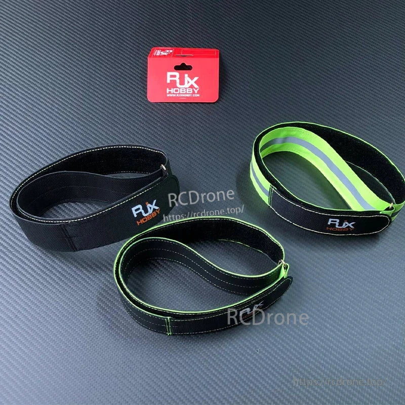 RJXHOBBY 40mm Kevlar Battery Strap, RJXHOBBY 40mm black Kevlar battery straps with green edging and reflective stripe, looped on tabletop