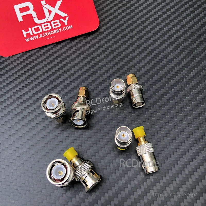 Assorted SMA to BNC coaxial RF adapters with gold-tone center pins and yellow protective caps