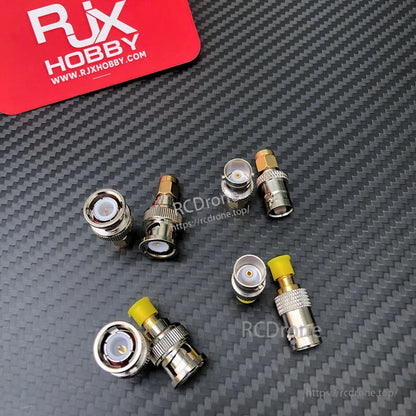 Assorted SMA to BNC coaxial RF adapters with gold-tone center pins and yellow protective caps