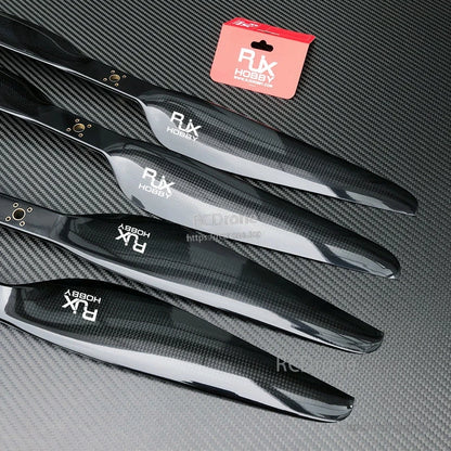 RJXHOBBY carbon fiber propeller blades with glossy black finish laid out on a textured carbon surface