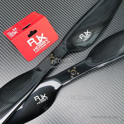 RJXHOBBY carbon fiber propellers with glossy black finish and reinforced hub on textured background