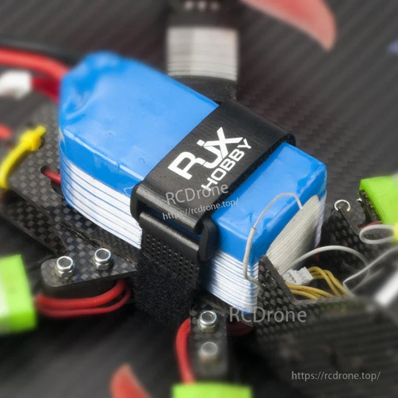 RJXHOBBY Non-Slip Silicone Battery Strap, RJXHOBBY black battery strap securing a blue LiPo pack on a carbon fiber FPV drone frame