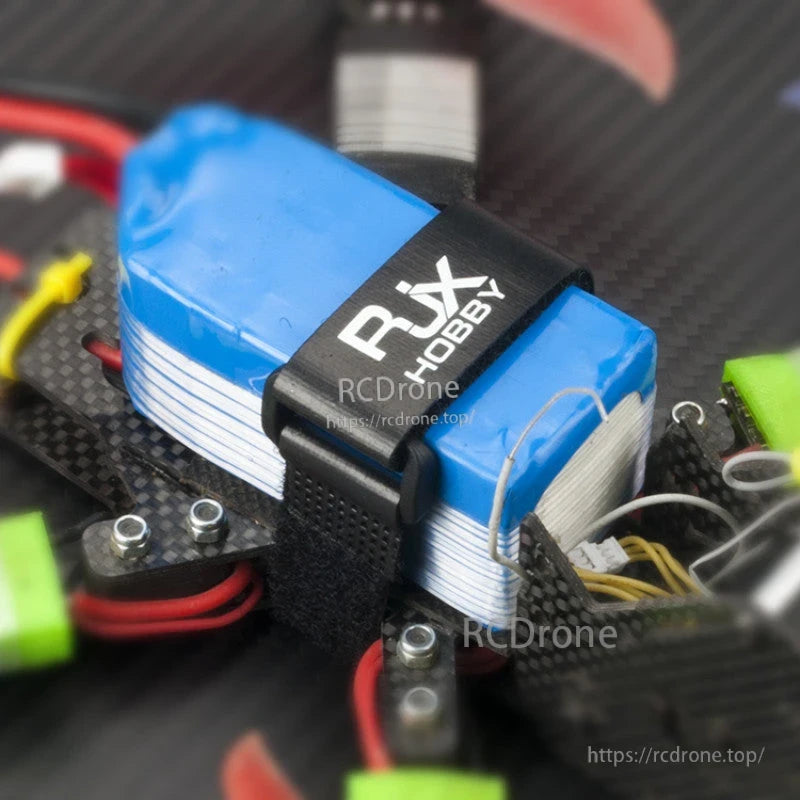 RJXHOBBY Non-Slip Silicone Battery Strap, RJXHOBBY black silicone battery strap securing a blue LiPo pack on a carbon fiber FPV drone frame