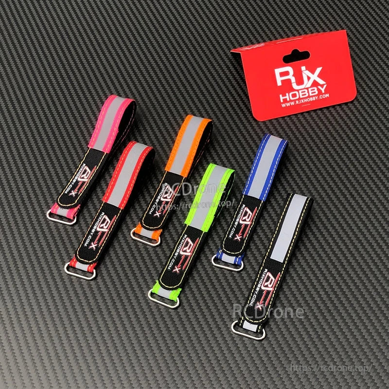 RJXHOBBY Reflective Battery Strap 2pcs, RJXHOBBY reflective battery straps with metal buckles in assorted colors on a carbon fiber background
