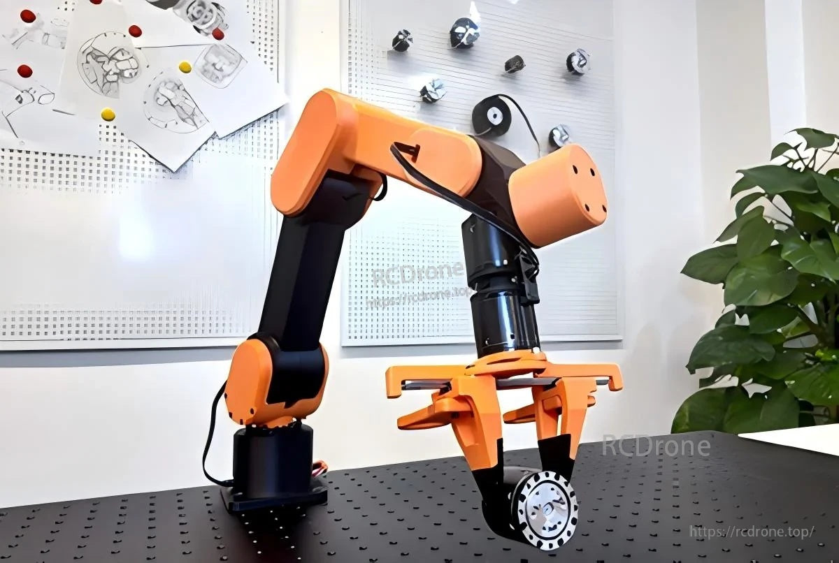 Edulite A3 desktop robotic arm on workbench, orange-and-black 6-axis arm with parallel gripper