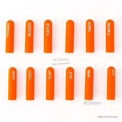 Orange long labeled silicone switch covers, 12-piece set laid out on white background